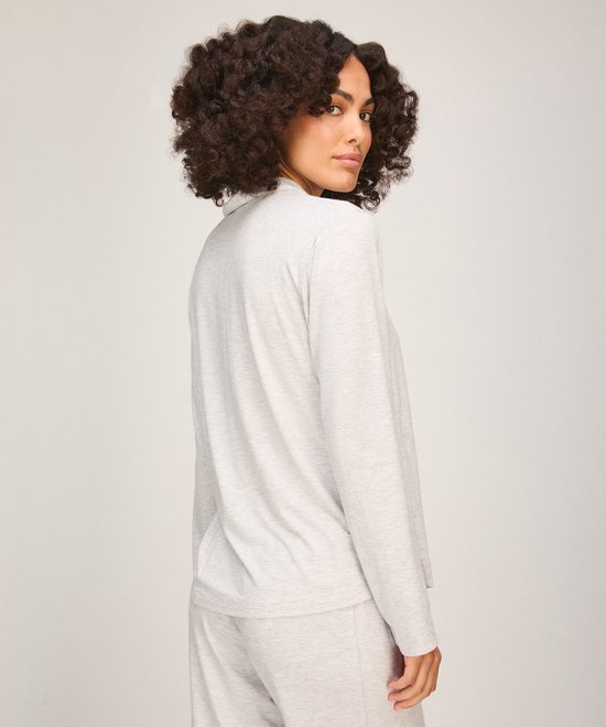 Model toont de achterkant van het lichtgrijze pyjamashirt, kijkend over de schouder.