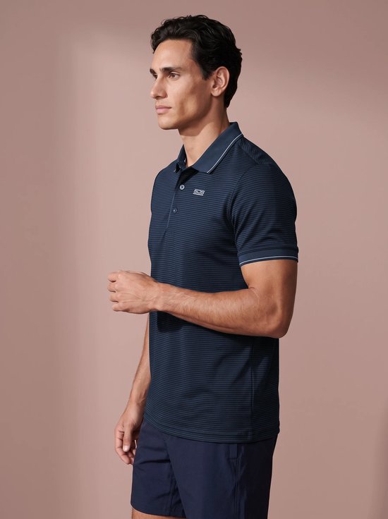 Zijaanzicht van een model in een donkerblauw gestreept poloshirt met witte details op de kraag en mouwen.