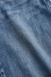 Textuur van lichtblauwe denim met een stonewash-look en lichte kreukels.