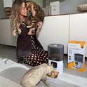 Vrouw met een Bengaalse kat naast de witte 6L Viervoeter Feed Pro automatische voerbak voor honden en katten.