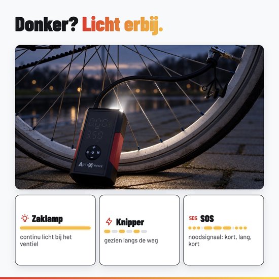 AutoXtreme compressor met ingebouwde zaklamp in het donker, bij een fietswiel. Toont SOS- en knipperfuncties.