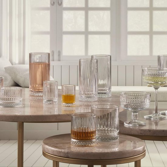 Een verzameling glazen met verticale ribbels en een diamantpatroon aan de basis, gevuld met diverse dranken.