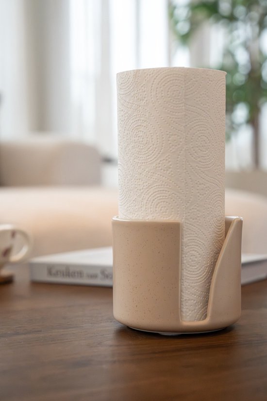 Gros plan sur un porte-essuie-tout en céramique beige avec un rouleau d'essuie-tout à motifs spirales.