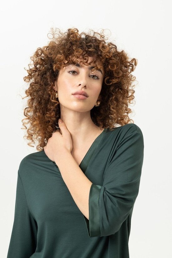 Model draagt een donkergroen Mey T-shirt met V-hals en driekwartmouwen.