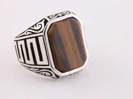 Zilveren ring met een rechthoekige tijgeroog steen en gestileerde geometrische versieringen op de band.