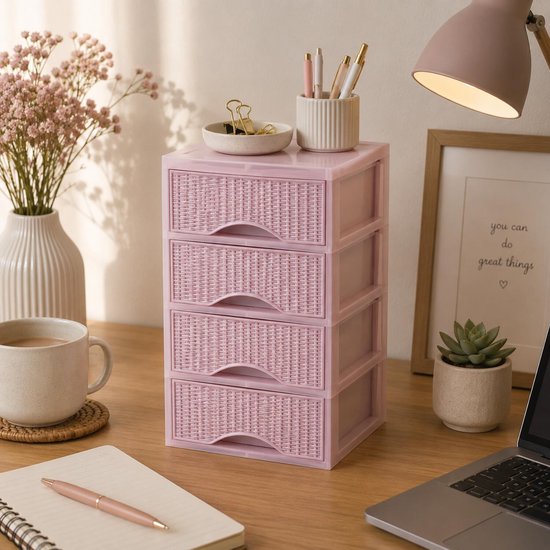 Roze ladeblokje op een bureau, naast een vaas met bloemen en een mok koffie. Het ladeblok heeft een rotan-look textuur en gebogen handgrepen.