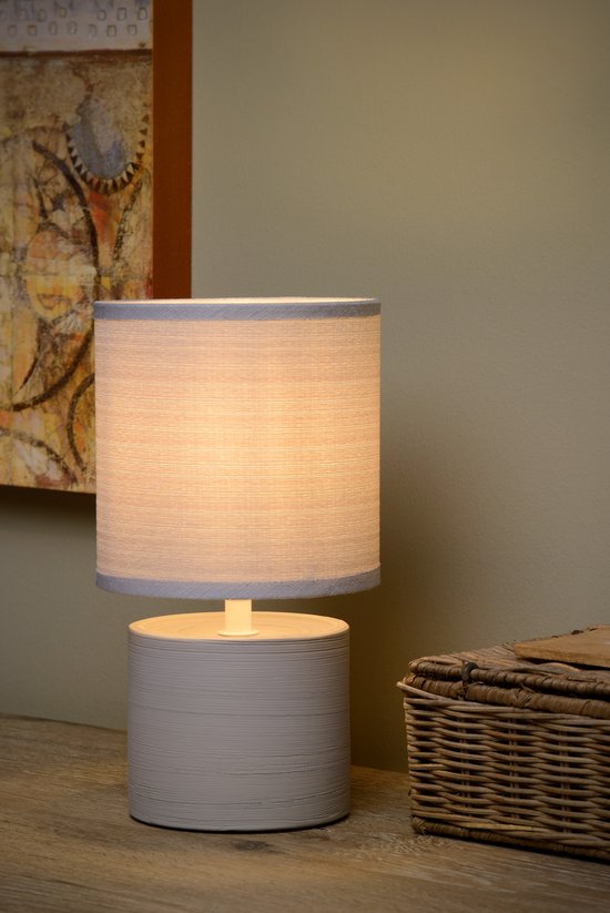 Lampe de table grise avec base cylindrique et abat-jour en tissu avec bordure grise.