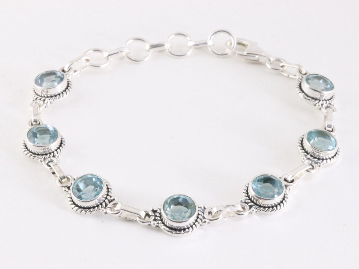 Bewerkte zilveren schakelarmband met blauwe topaas
