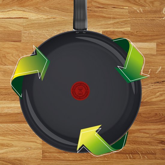 Zwarte Tefal koekenpan met groene pijlen die een cyclus aangeven, op een houten ondergrond.