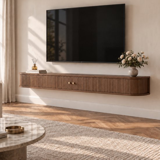 Zwevend tv-meubel van bruin hout met lattenontwerp en afgeronde hoeken onder een tv aan de muur.