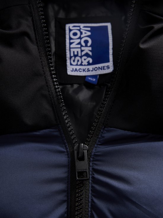 Close-up van de rits en het 'JACK & JONES' label in de kraag van een tweekleurige jas.