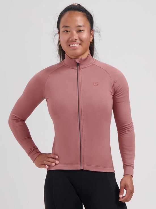 Vrouw draagt een oudroze Rogelli Essential II fietsshirt met lange mouwen, opstaande kraag en zwarte rits.