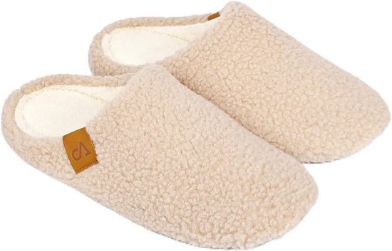 Beige teddy pantoffels met zachte witte voering en bruin merklabel.