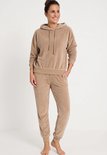 Beige Apollo velours huispak met capuchon, lange mouwen en bijpassende broek, gedragen door een model.