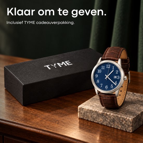 Horloge met blauwe wijzerplaat naast een zwarte TYME cadeauverpakking op een houten ondergrond.