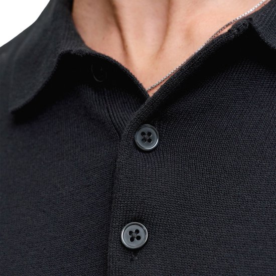 Donslag van zwart gebreid poloshirt met twee knopen.
