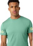 Man in lichtgroen sportshirt met gouden opdruk 'BORG' op de mouw.