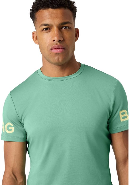 Man in lichtgroen sportshirt met gouden opdruk 'BORG' op de mouw.