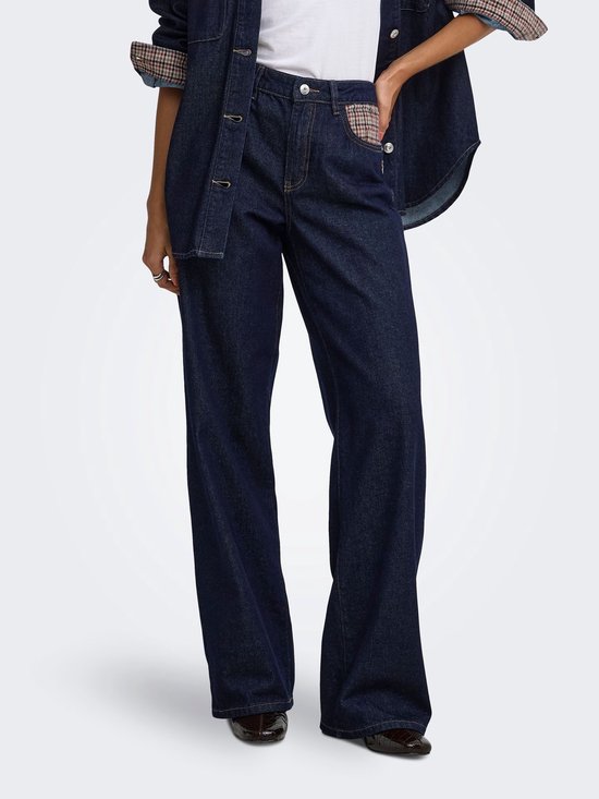 Model in donkerblauwe wijde jeans met plaiddetails en denim jack.