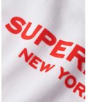 Gros plan d'un sweat blanc avec l'inscription rouge "SUPERDRY NEW YORK".