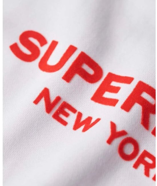 Gros plan d'un sweat blanc avec l'inscription rouge "SUPERDRY NEW YORK".