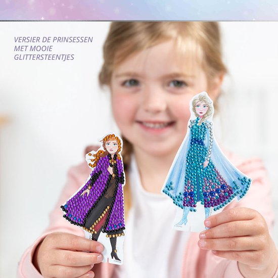 Kind versiert twee Frozen-prinsessenfiguren met glimmende diamond painting steentjes.