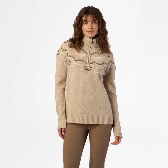 Model in een beige HV Polo trui met halve rits en geometrische details bij de hals en schouders.