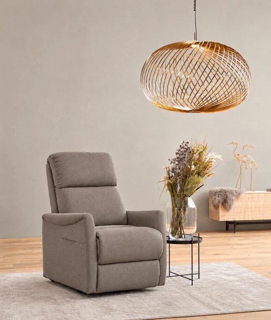 Taupekleurige Finlandic F-601 relaxfauteuil in een modern interieur met een gouden hanglamp erboven.