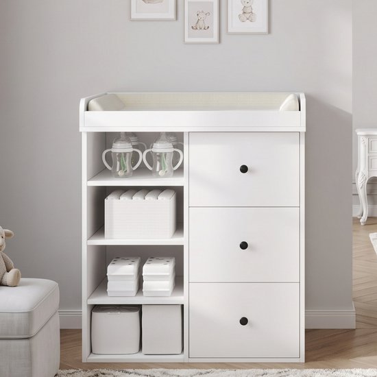 Witte commode met drie lades en open opbergvakken, gevuld met flessen en manden voor babyproducten.