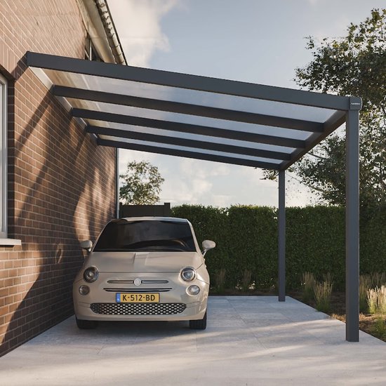 Moderne grijze carport met een helder polycarbonaat dak, naast een bakstenen huis, met een lichtbeige Fiat 500 eronder.