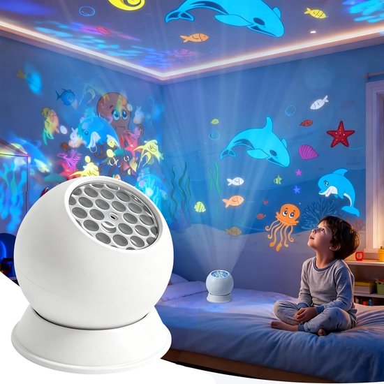 Un garçon est assis sur un lit et regarde un projecteur blanc qui projette des créatures marines et des vagues colorées sur le plafond et les murs.