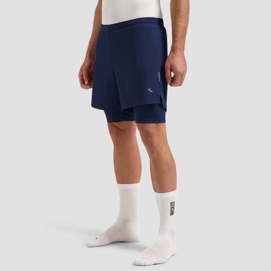 Zijaanzicht van een man in een donkerblauwe 2-in-1 hardloopshort, witte sokken met logo.