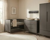 Babykamer in donkergrijs met een bedje, commode, kast en wandrek, in een lichte kamer.