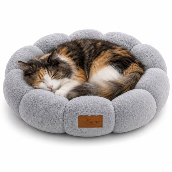 Panier rond pour chat gris avec bordure douce en forme de fleur. Un chat calico dort en boule.