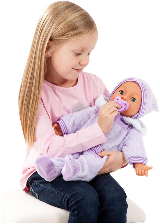 Een meisje met blond haar houdt een babypop in een paars sneeuwpak vast en geeft de pop een paarse speen.