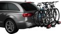 Zwarte Thule fietsendrager voor 3 fietsen, gemonteerd op een auto.