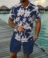 Man op een steiger in een donkerblauw overhemd met palmbomenprint en marineblauwe short.