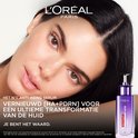 Vrouw met donker haar en bruine ogen, met naast haar een flesje L'Oréal Paris Revitalift serum.