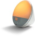 Philips wake-up light met een rond ontwerp, witte basis en een verlichte, oranje kap. Tijd 7:00 wordt weergegeven op het scherm.