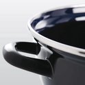 Close-up van het zwarte emaille handvat van een braadpan met zilverkleurige rand.