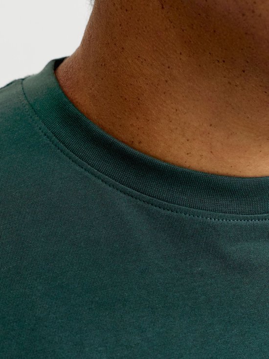 Close-up van de halslijn van een donkergroen T-shirt met stiksels.