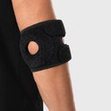 Zwarte elleboogbrace met klittenbandsluiting op een mannenarm.