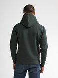 Donkergroene hoodie met lange mouwen, gezien vanaf de achterkant op een man met spijkerbroek.