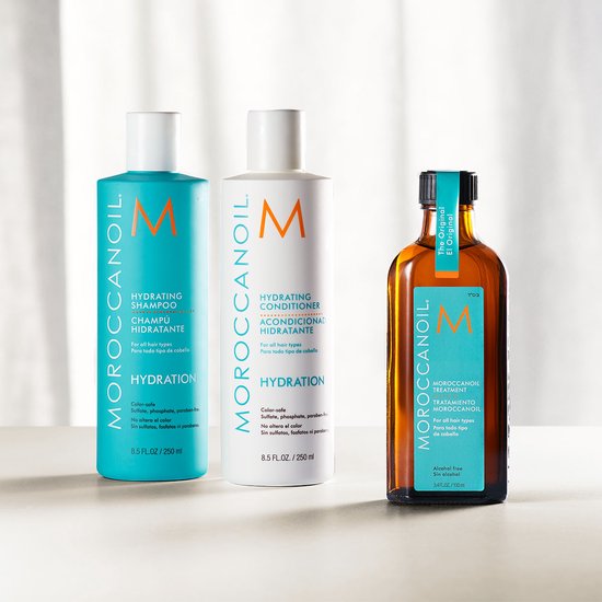 Moroccanoil Hydrating Shampoo, Conditioner en Treatment in glazen fles, op een witte achtergrond.