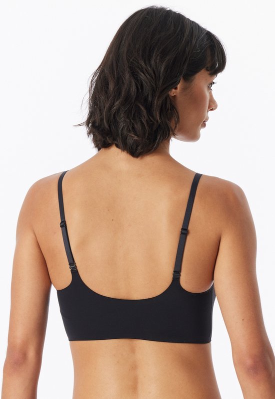Achterkant van het model die een zwarte bustier met verstelbare bandjes draagt.