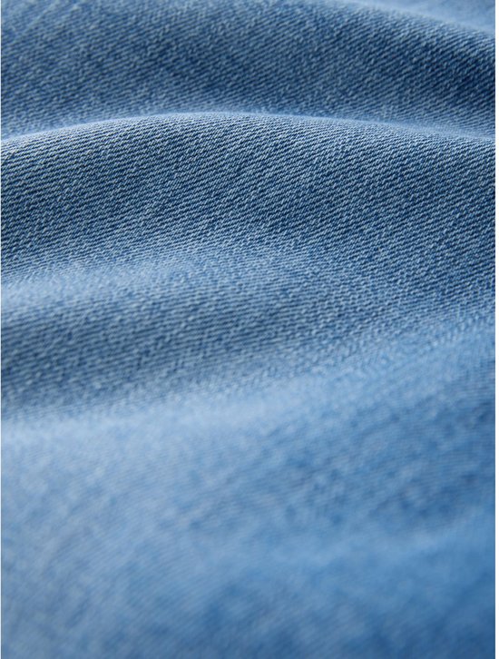 Close-up van lichtblauwe denim stof met een textuur van de weving.