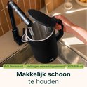 Zwarte waterkoker wordt gevuld onder een kraan. Roestvrijstalen binnenkant, verborgen verwarmingselement.