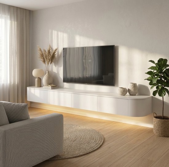 Zwevend Japandi tv-meubel in wit met gebogen zijkanten, verlichting onderaan, een tv, een lamp, vazen en een bank.