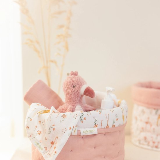 Panier rose à imprimé flamant rose, rempli d'une peluche et de produits de soin.