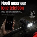 Een hand houdt een smartphone met 1% batterij vast, verbonden met een zwart fietslicht met powerbank functie.